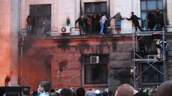 Люди выбираются на карниз здания во время пожара в Доме профсоюзов в Одессе