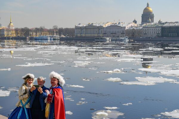 Мужчина фотографируется с актерами на стрелке Васильевского острова в Санкт-Петербурге