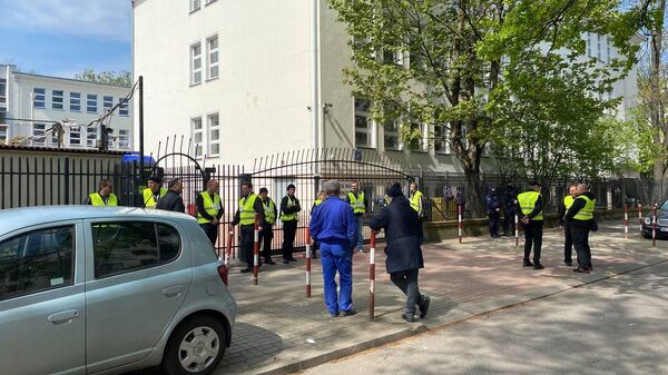 Представители мэрии в сопровождении полиции стоят возле ворот школы при российском посольстве в Варшаве