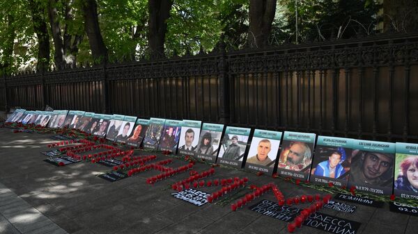 Фотографии жертв трагедии в Доме профсоюзов в Одессе, принесенные участниками акции, посвященной девятой годовщине трагедии, у здания посольства Украины в Москве