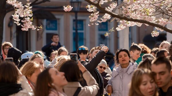 Люди у цветущей сакуры в Саду дружбы в Санкт-Петербурге