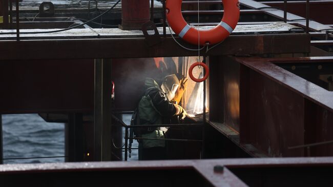 Сварщик на строительной площадке морского порта в Мурманской области