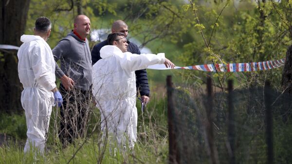 Судебно-медицинские эксперты осматривают место происшествия в деревне Дубона