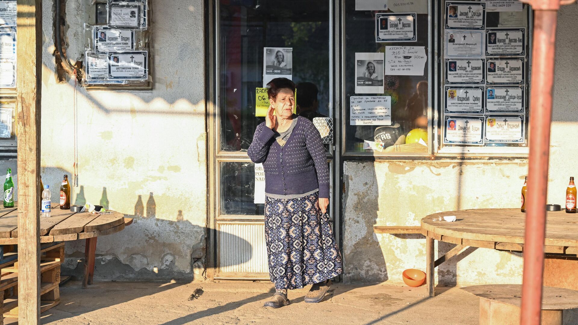 Местная жительница стоит около магазина в окне которого развешаны некрологи в деревне Дубона, где произошла стрельба - РИА Новости, 1920, 05.05.2023
