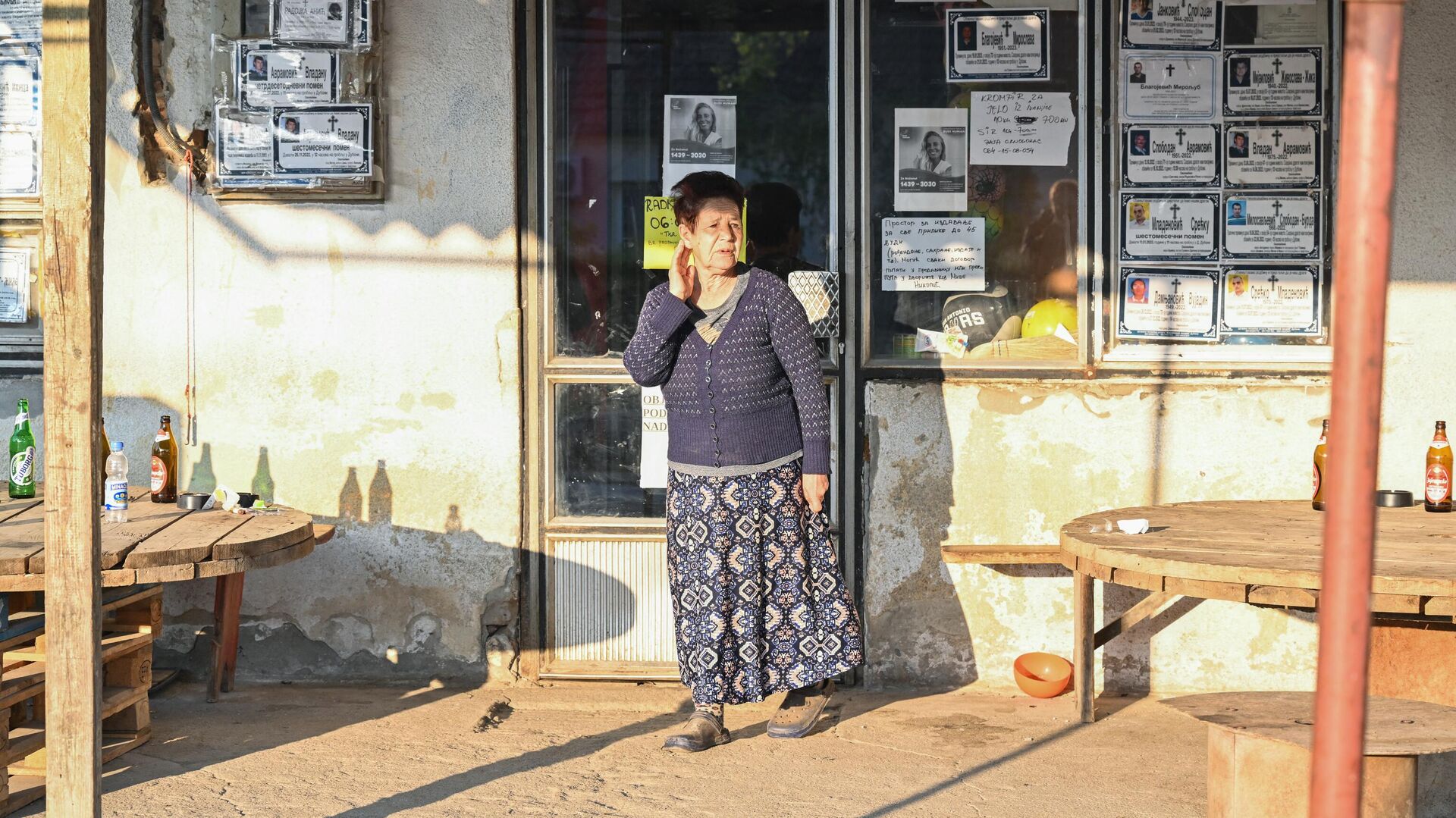 Местная жительница стоит около магазина в окне которого развешаны некрологи в деревне Дубона, где произошла стрельба - РИА Новости, 1920, 05.05.2023
