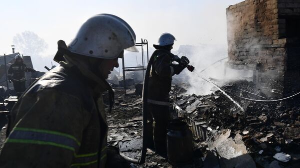 Сотрудники противопожарной службы МЧС тушат пожар