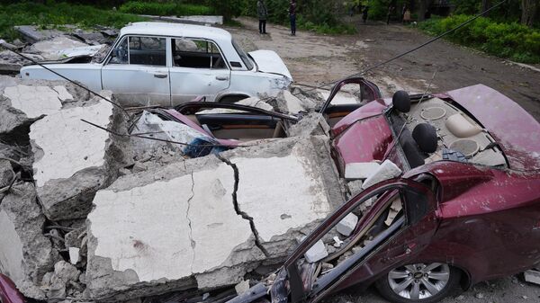 Машина, поврежденная бетонной плитой в результате обстрела со стороны ВСУ из РСЗО HIMARS, в Стаханове