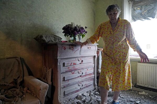 Женщина в своей квартира, поврежденной в результате обстрела со стороны ВСУ из РСЗО HIMARS, в Стаханове