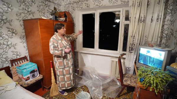 Жительница у окна квартиры, разбитого в результате обстрела Горловки со стороны ВСУ