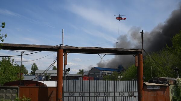 Вертолет МЧС России тушит пожар на складе предприятия по переработке отходов, на котором загорелись покрышки, в Дзержинском Московской области