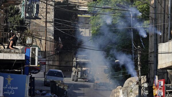 Израильские силы безопасности применяют слезоточивый газ в городе Ниблус для разгона палестинцев во время протеста против действий Израиля 