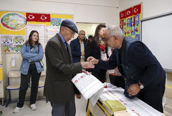 Мужчина получает бюллетени на избирательном участке в Анкаре
