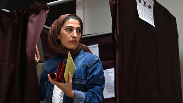 Женщина на избирательном участке во время голосования на всеобщих выборах в Стамбуле