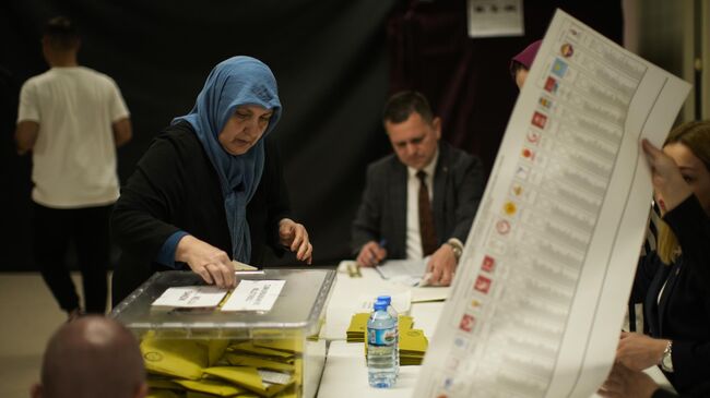 Женщина голосует на избирательном участке в Стамбуле