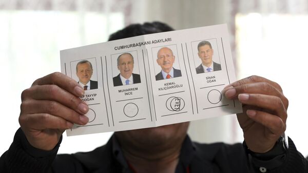 Мужчина демонстрирует бюллетень с голосом за Кемаля Кылычдароглу на избирательном участке в Стамбуле