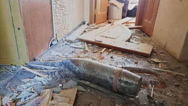 Снаряд на полу квартиры жилого дома, поврежденного в результате обстрела ВСУ города Ясиноватая