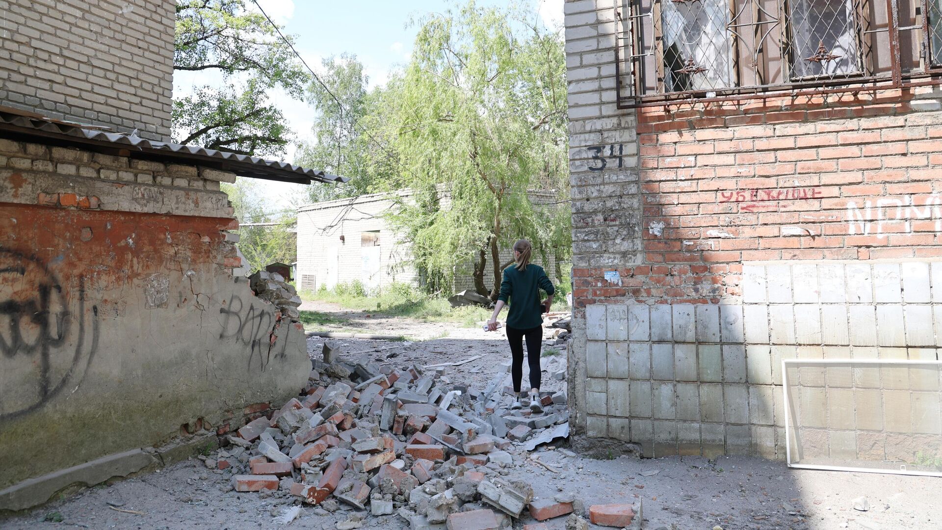 Девушка во дворе жилого дома, пострадавшего в результате обстрела ВСУ города Ясиноватая - РИА Новости, 1920, 17.05.2023