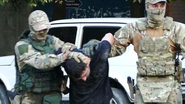 Сотрудники ФСБ России задерживают мужчину, причастного к восстановлению боевых свойств гражданских образцов оружия в подпольных мастерских и их сбыту. Стоп-кадр видео