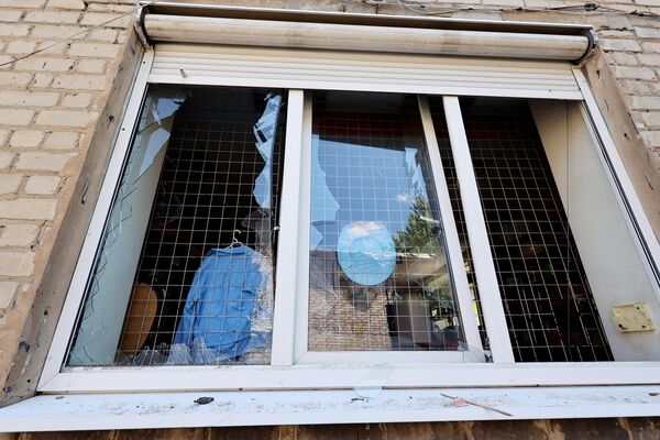 Выбитые стекла в окнах магазина в Куйбышевском районе Донецка, частично разрушенного в результате обстрела ВСУ