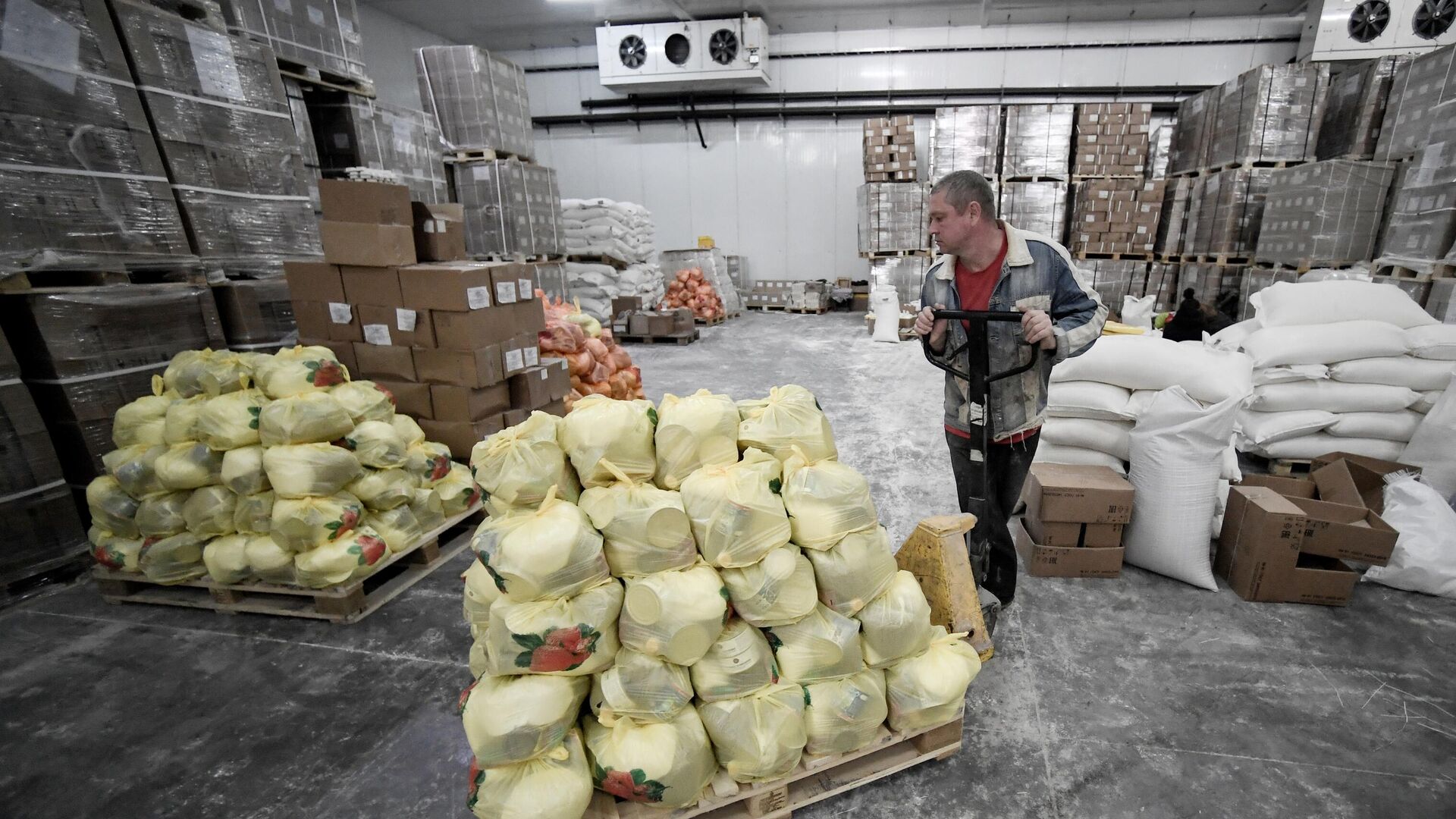 Волонтер перемещает телегу с продуктовыми наборами на складе в Бердянске - РИА Новости, 1920, 28.06.2023
