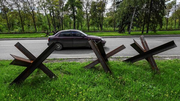 Автомобиль проезжает мимо противотанковых заграждений в Краматорске