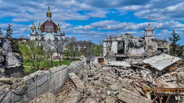 Разрушенное здание Донецкого академического областного драматического театра в Мариуполе. Слева — храм Покрова Божией Матери