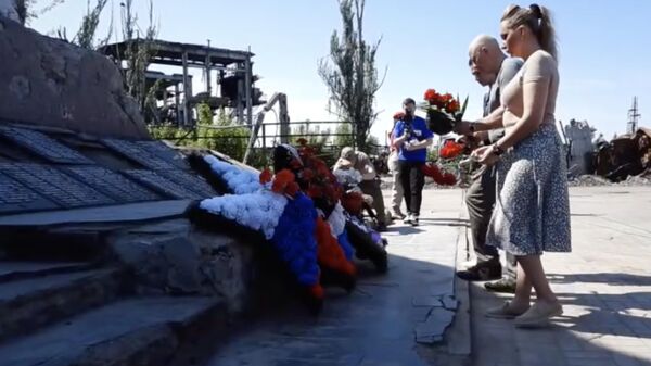 Жители Мариуполя возлагают цветы к монументу Освободителям Донбасса в годовщину освобождения от украинских националистов. Кадр видео