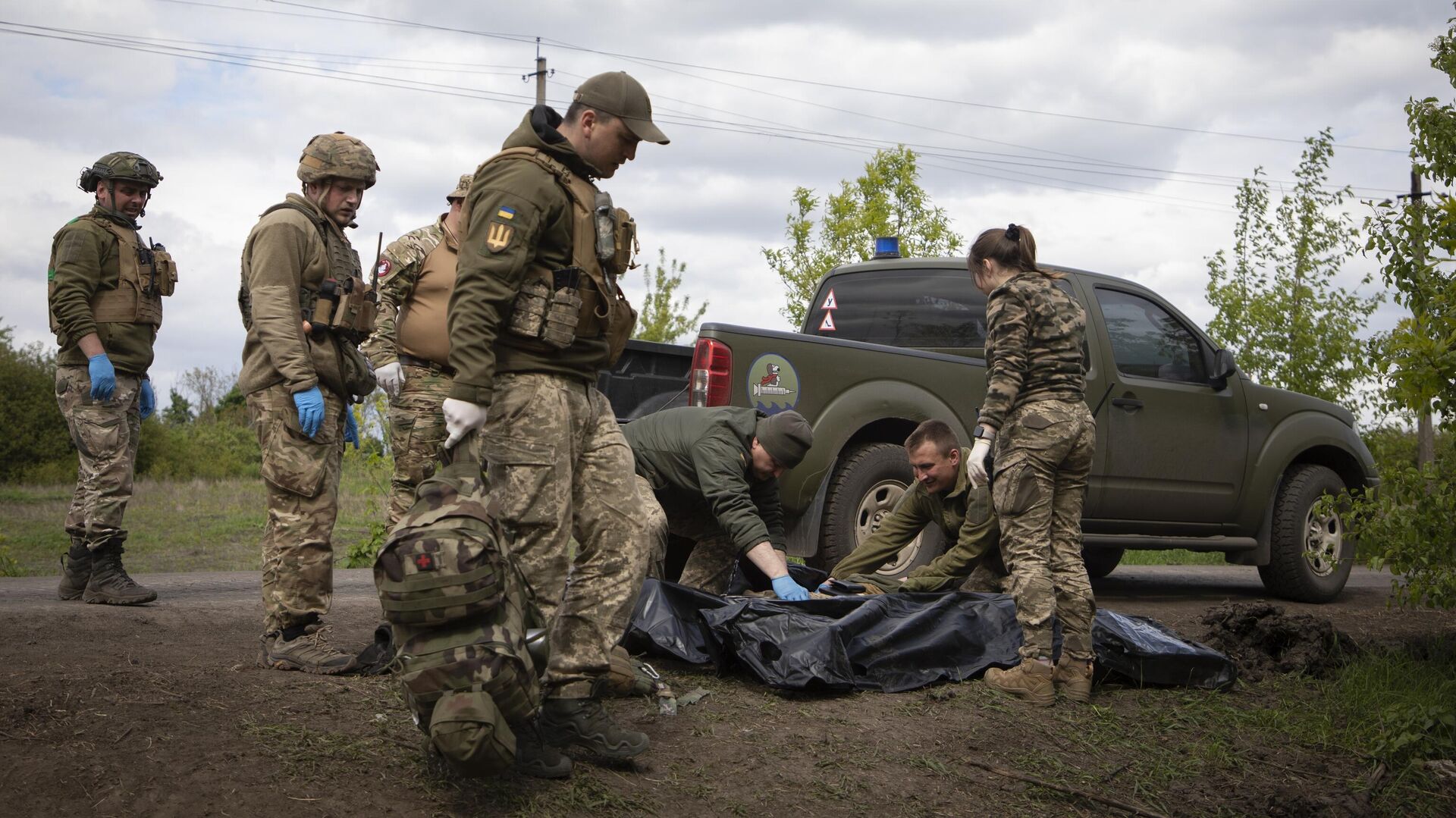 Военные медики укладывают тела убитых украинских солдат в пластиковые пакеты - РИА Новости, 1920, 29.05.2023