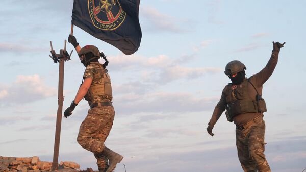 Бойцы ЧВК Вагнер водружают свой флаг на самой высокой точке города