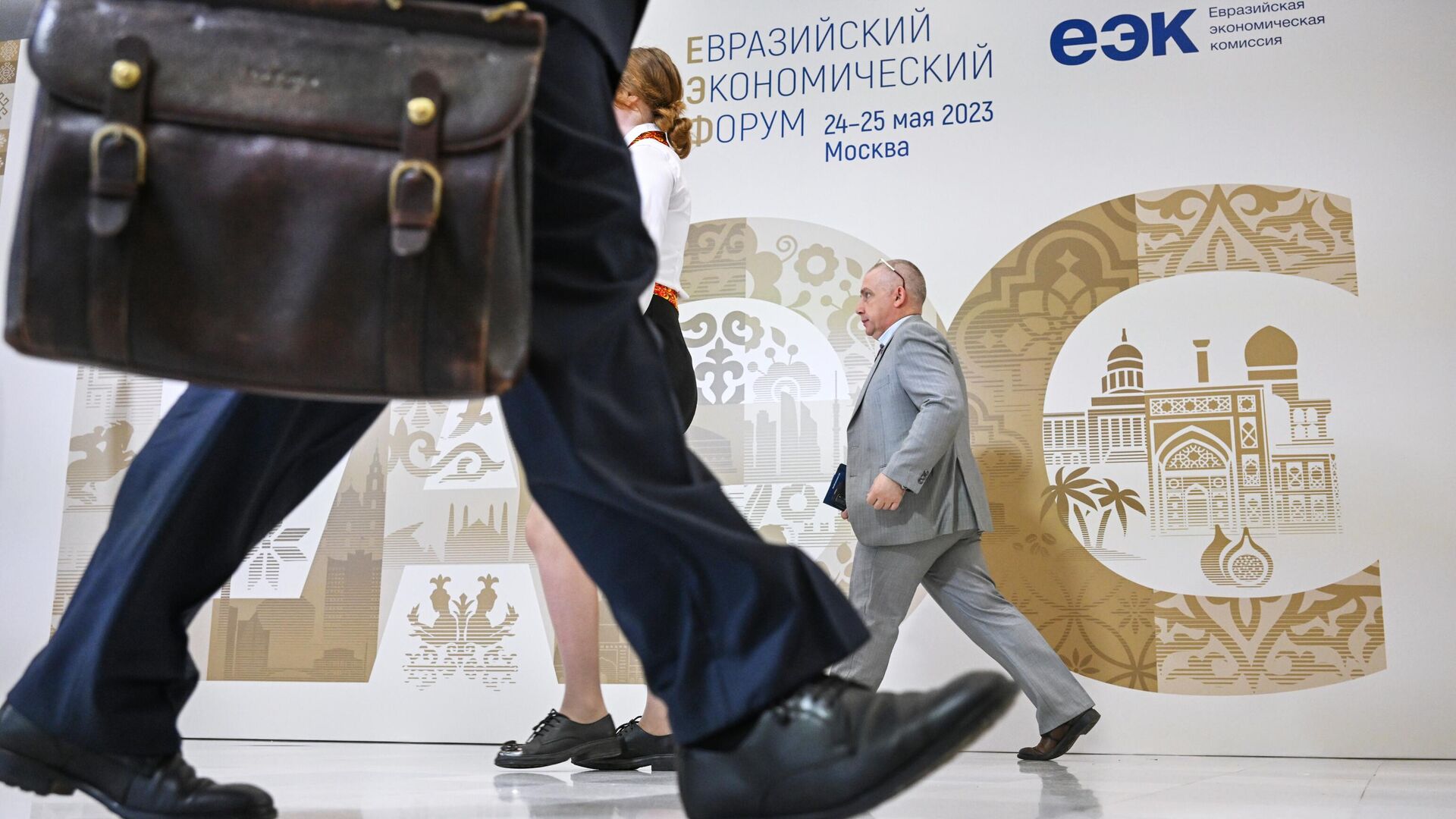 Участники проходят рядом со стендом с символикой Евразийского экономического форума в Москве - РИА Новости, 1920, 25.05.2023