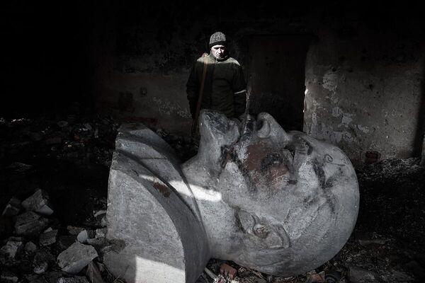 Житель Луганска у бюста В.И. Ленина, демонтированного киевскими властями и спрятанного в подвале разрушенного здания. ЛНР,  2022