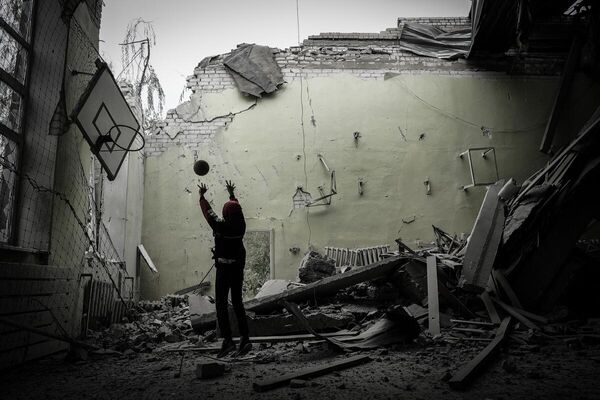 Молодой человек в спортивном зале разрушенного здания школы в Рубежном. 
ЛНР, 2022

