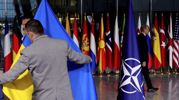 Сотрудник службы протокола поправляет украинский флаг в штаб-квартире НАТО. Архивное фото