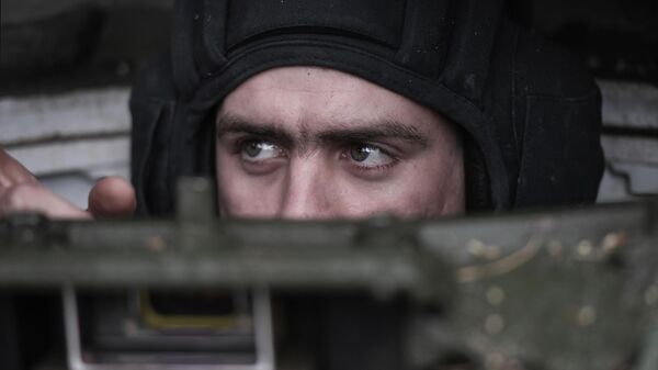 Член танкового экипажа осматривает поступивший в подразделение танк Т-90 Прорыв
