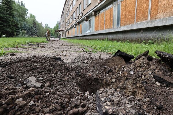Воронка от взрыва у здания Научно-Исследовательского института, поврежденного в результате обстрела со стороны ВСУ из РСЗО HIMARS, в Калининском районе Донецка