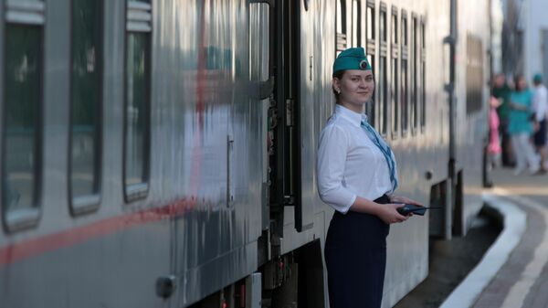 Проводник у скорого двухэтажного поезда Таврия из Москвы на железнодорожном вокзале Феодосии