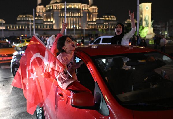Сторонники действующего президента Турции Реджепа Тайипа Эрдогана радуются его победе во втором туре президентских выборов в Турции на площади Таксим в Стамбуле