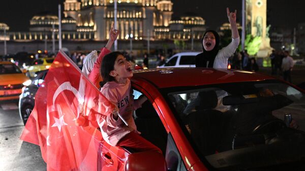 Сторонники действующего президента Турции Реджепа Тайипа Эрдогана радуются его победе во втором туре президентских выборов в Турции на площади Таксим в Стамбуле