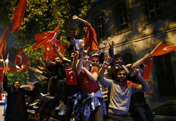 Сторонники действующего президента Турции Реджепа Тайипа Эрдогана радуются его победе во втором туре президентских выборов в Турции на одной из улиц в Стамбуле