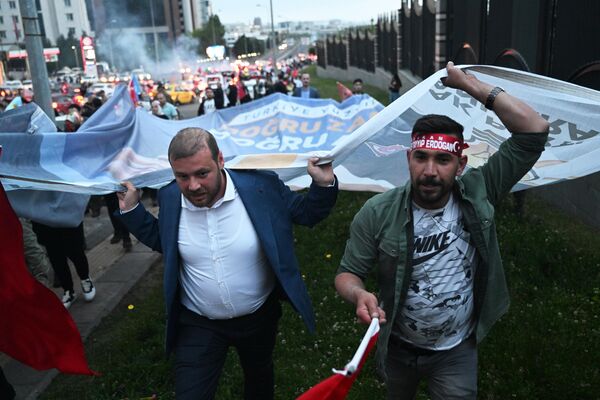 Сторонники действующего президента Реджепа Тайипа Эрдогана у президентского дворца в Анкаре радуются предварительным итогам второго тура президентских выборов в Турции