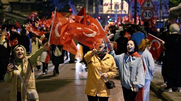 Сторонники действующего президента Турции Реджепа Тайипа Эрдогана радуются его победе во втором туре президентских выборов в Турции на одной из улиц в Стамбуле