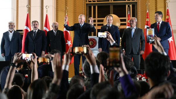 Президент Турции Реджеп Тайип Эрдоган (в центре) выступает перед сторонниками на площади у Президентского дворца в Анкаре