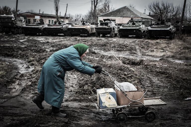 Пожилая женщина возвращается домой с полученной гуманитарной помощью. Деревня Трехизбенка.