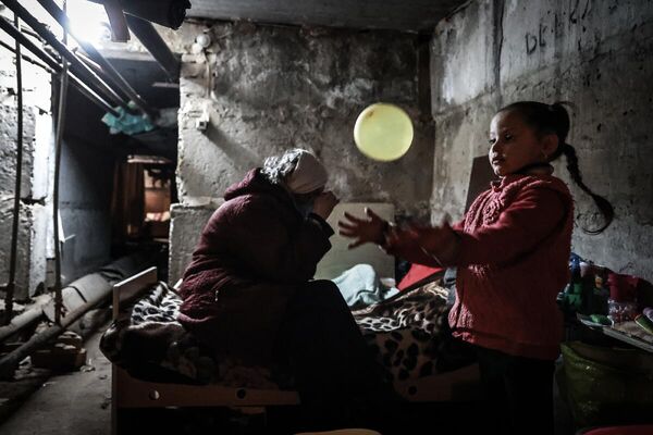 Семья местных жителей прячется в подвале здания во время обстрела города Рубежное. ЛНР, 2022

