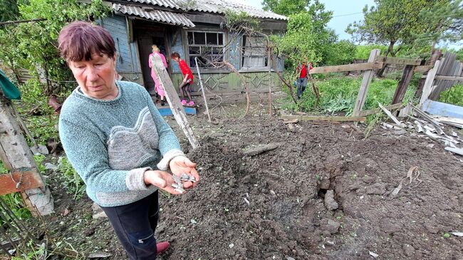 Жительница Горловки Донецкой народной республики демонстрирует осколки снарядов, которыми ВСУ обстреляли населенный пункт. 29 мая 2023