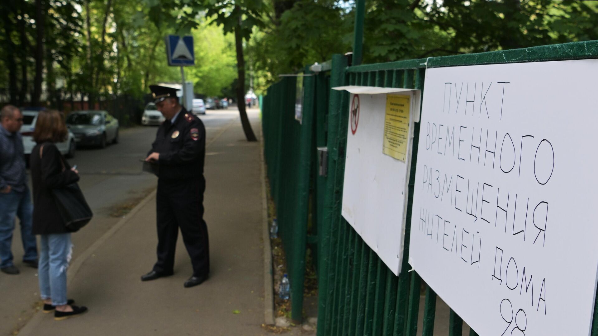 Сотрудник полиции у пункта временного размещения для жителей жилого дома, пострадавшего в результате атаки беспилотника, на улице Профсоюзная в Москве - РИА Новости, 1920, 30.05.2023