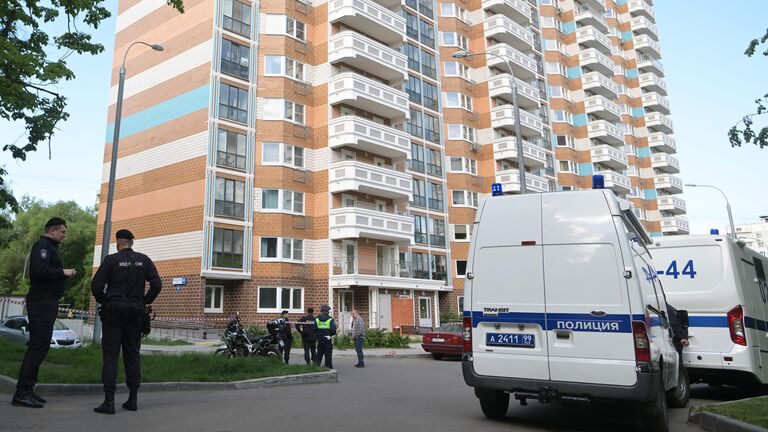 Сотрудник полиции у жилого дома, пострадавшего в результате атаки беспилотника, на улице Профсоюзная в Москве