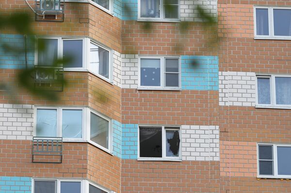 Разбитое окно жилого дома, пострадавшего в результате атаки беспилотника, на улице Профсоюзная в Москве