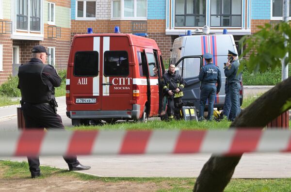Сотрудники экстренных служб у жилого дома, пострадавшего в результате атаки беспилотника, на улице Профсоюзная в Москве
