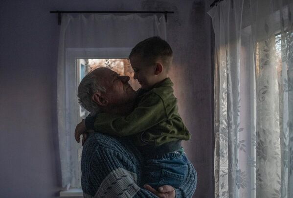 Виктор Александрович во время встречи с внуком Самсоном в своем доме в станице Луганская. 
ЛНР, 2022